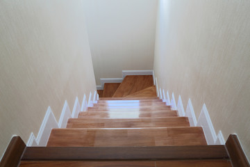 The light that shines through the window of a wooden staircase