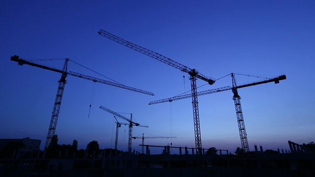 construction site: cranes over clear sky at sunset