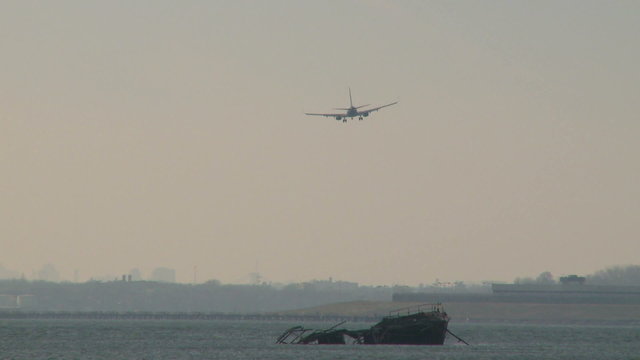 Plane coming in for a landing over the water 
