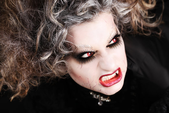 vampire woman portrait with mouth open showing teeth canines, halloween make up