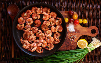 There are shrimps in a cast iron skillet