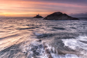 Obraz premium Dawn at Mumbles Lighthouse, Swansea, shot from the entrance to the pier