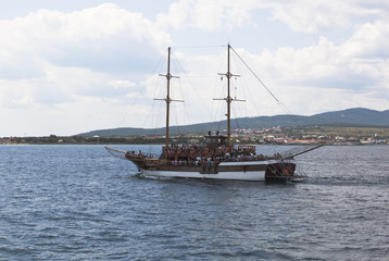 Парусное судно "Корсар" плывёт в Геленджикской бухте на фоне Тонкого мыса, Краснодарский край, Россия