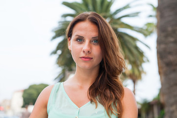 Naklejka premium A portrait of a girl, sitting near the palm tree