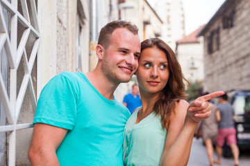 A couple standing on the street and having fun. Positive emotions.