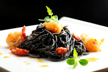 Fine dining, Italian squid ink pasta with shrimp basil selective focus