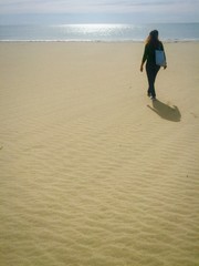 una donna cammina da sola su una spiaggia a settembre