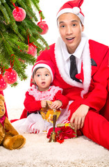 Happy family in Christmas eve at home sitting near decorated fir