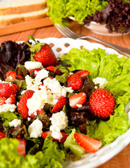 Green salad with strawberries, cottage cheese and olive oil