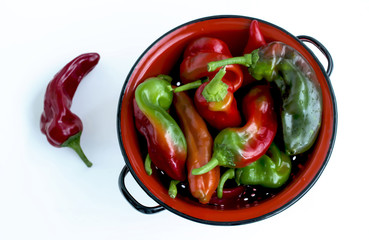 Various peppers in a colander from above