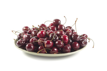 Ripe cherry on a green ceramic plate isolated on white