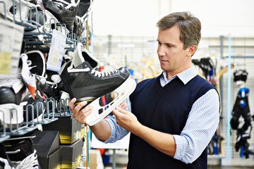 Man chooses hockey skates in sports shop