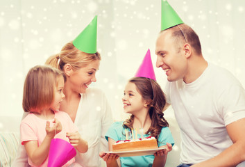 happy family with two kids in party hats at home