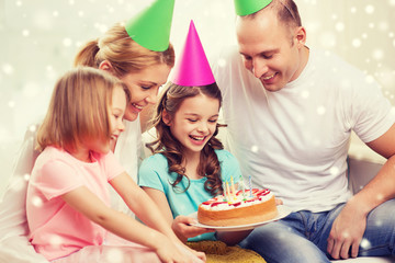 happy family with two kids in party hats at home