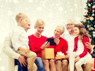 smiling family with tablet pc and gift box at home