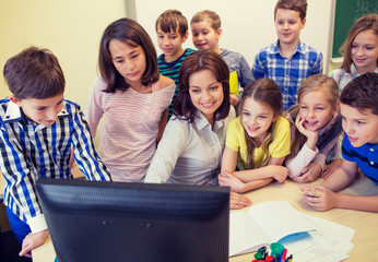 group of kids with teacher and computer at school