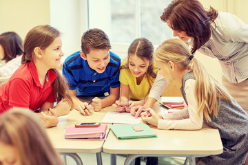 group of school kids writing test in classroom