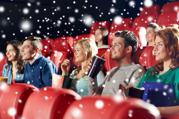 happy friends with popcorn and drinks in cinema