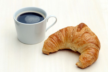 Tasse Kaffee, Croissant - Französisches Frühstück