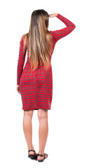 back view of standing young beautiful  woman.  girl  watching