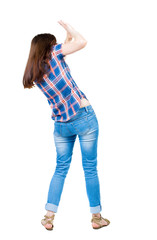 back view of woman  protects hands from what is falling from abo