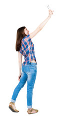 back view of standing young beautiful  woman and using a mobile