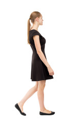 back view of walking  woman in dress.