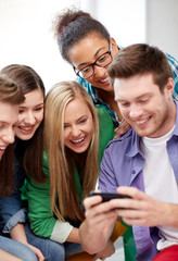 group of happy students with smartphone at school