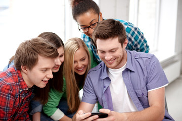 group of happy students with smartphone at school