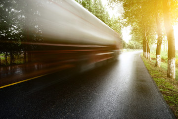 asphalt road with tree lawns under sunshine