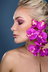 Portrait of beautiful sensual woman with orchid near her face