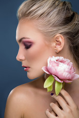 Close-up portrait of beautiful woman holding peony flower