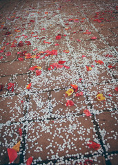 Rose petals and paper confetti laying at the ground after wedding ceremony