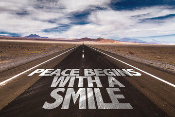 Peace Begins With a Smile written on desert road