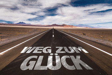 Road To Happiness (in German) written on desert road
