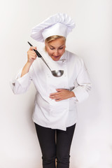 Young woman chef holding wooden spoon, smiling.