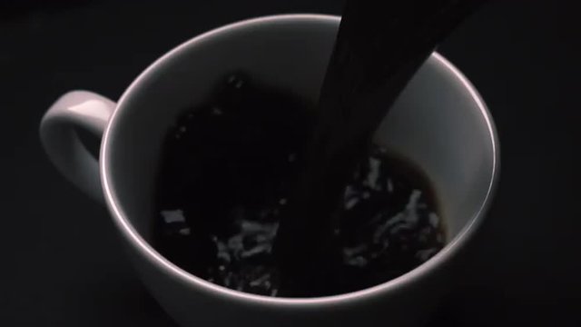 Pouring coffee on dark background