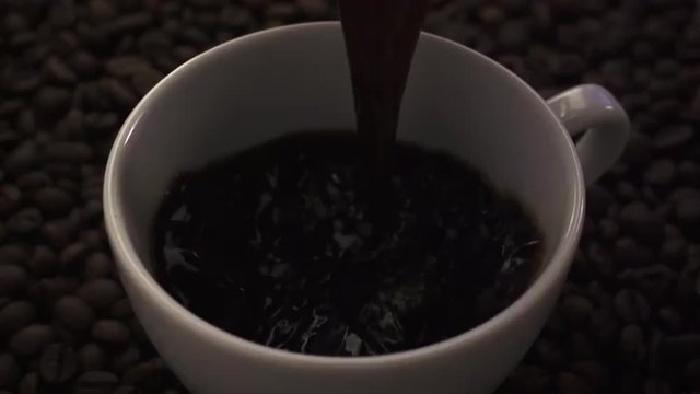 pouring black coffee on dark background