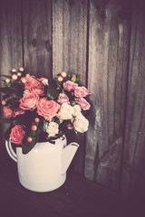 Bouquet of roses in vintage coffee pot