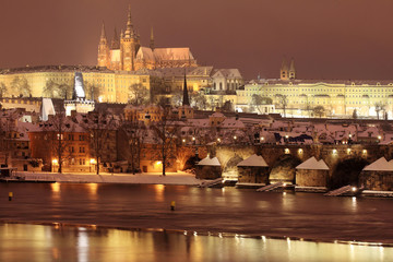 Fototapeta na wymiar Night romantic colorful snowy Prague gothic Castle with Charles Bridge, Czech Republic