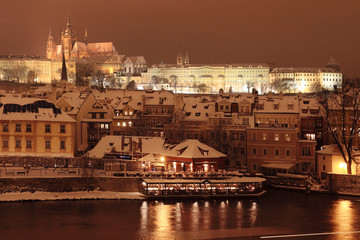 Night romantic colorful snowy Prague gothic Castle with Charles Bridge, Czech Republic