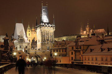 Obraz premium Night colorful snowy Prague gothic Castle with Bridge Tower and St. Nicholas' Cathedral and Sculptures from the Charles Bridge, Czech republic