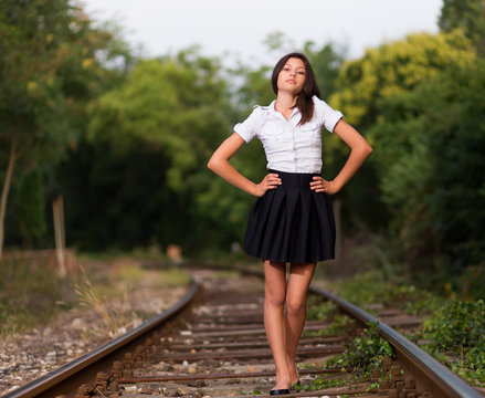 Young girl walking on railway line