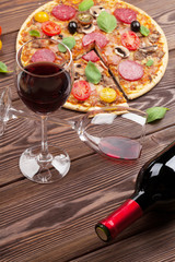 Italian pizza with pepperoni, tomatoes, olives, basil and red wi