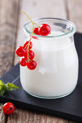 Homemade yoghurt with red currants in a glass jar.selective focus