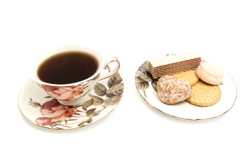 cup of tea and tasty sweets on white