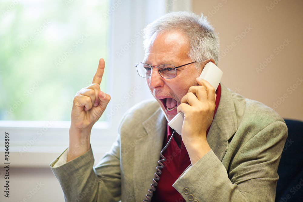 Wall mural angry senior businessman yelling at the phone