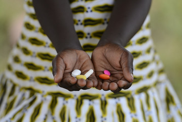 Black Girl Hands Cupped Medicine Health Background Symbol Pills Africa. Medicine Healthcare Symbol. Black African girl holding pills to cure diseases.  © Riccardo Niels Mayer