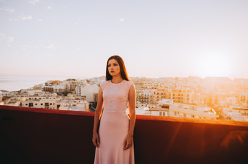 Fototapeta na wymiar Beautiful brunette young woman in a white evening dress. setting