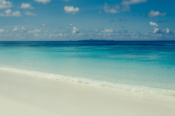blue sky with sea and beach - soft focus with film filter